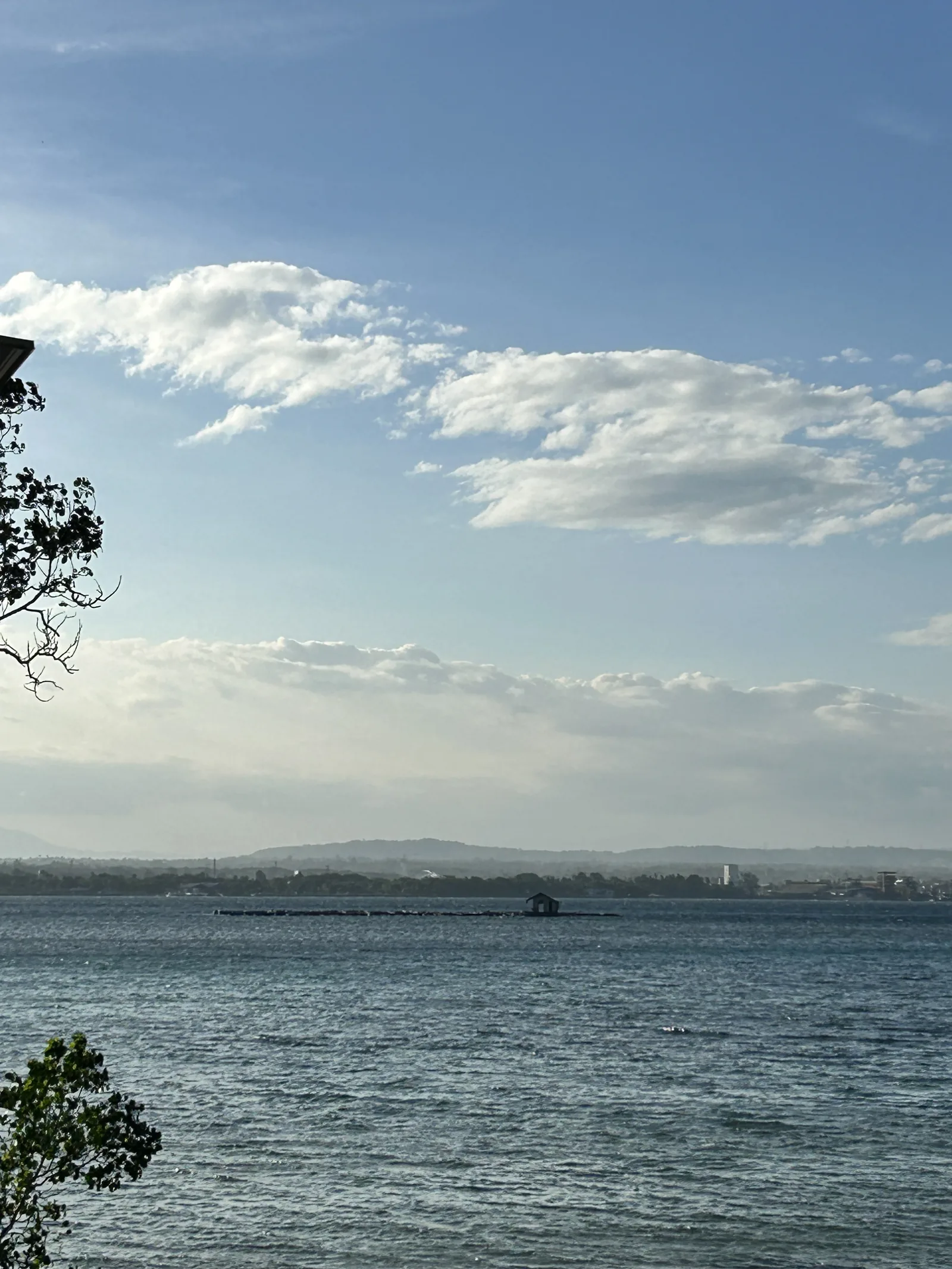 The view from BAUM across the water to the mainland, with a fish pen and a small hut in the channel.